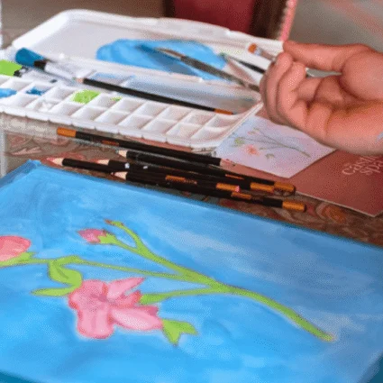 Guests engage in a relaxing art session, painting floral designs on canvas in the refined ambience of Dromoland Castle's elegant interior.
